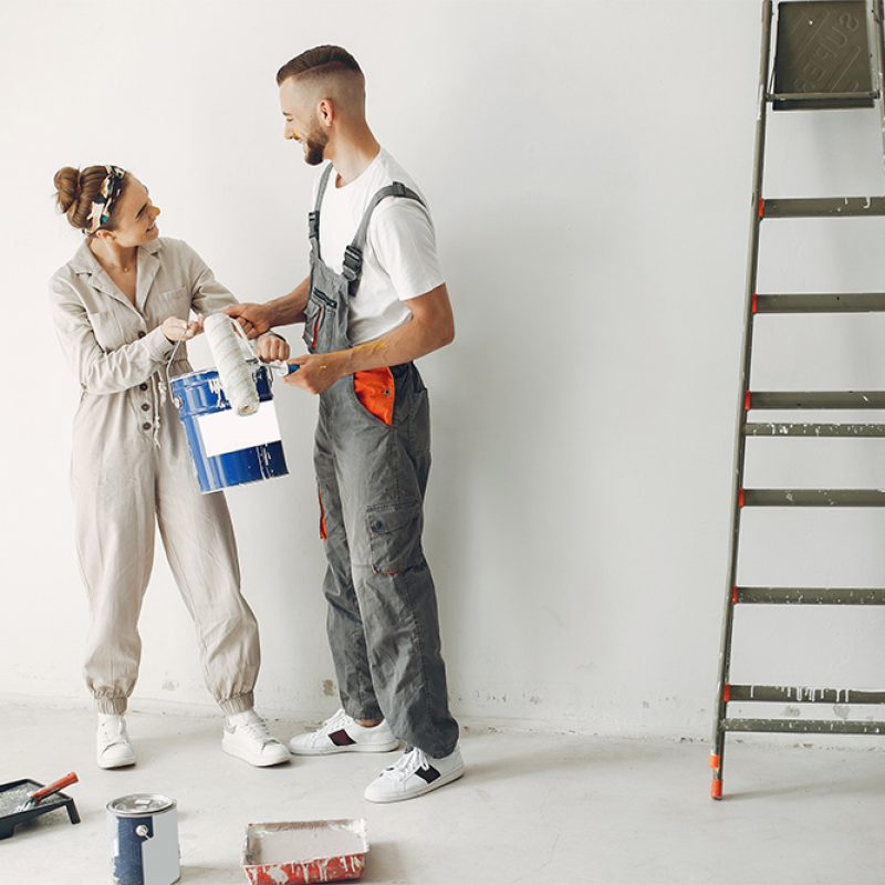 Family repairs. Couple at home. Woman in a overalls